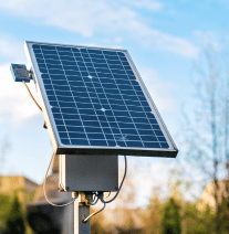 Solarni panel na stubu, plavi sa crnim ćelijama, na otvorenom.